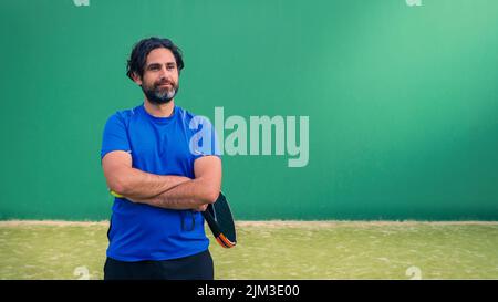 Mann, der Padel-Tennis mit Platz für Text spielt. Kaukasischer Spieler Sportler. Monitor des Padels mit schwarzem Schläger und Kopierraum. Racquet Sport Gam Stockfoto