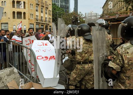 Beirut, Libanon. 04. August 2022. Familien vom 04. August 2020 in Beirut stoßen auf den Hafen und Aktivisten auf libanesische Soldaten, die während eines Protestes am Haupteingang des libanesischen parlaments anlässlich des 2.. Jahrestages des Vorfalls symbolische Särge werfen. Ein Teil von Beirut verwüstete Getreidesilos stürzten während des Jahrestages ein. Kredit: Stringer/dpa/Alamy Live Nachrichten Stockfoto