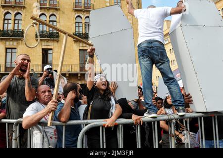 Beirut, Libanon. 04. August 2022. Aktivisten und Familien von Opfern des 04. August 2020 der Hafen von Beirut ruft während eines Protestes zum 2.. Jahrestag des Vorfalls Slogans vor dem Eingang des parlaments. Ein Teil von Beirut verwüstete Getreidesilos stürzten während des Jahrestages ein. Kredit: Stringer/dpa/Alamy Live Nachrichten Stockfoto