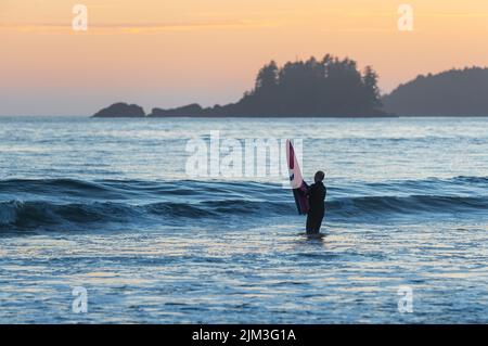 Surfer mit Surfbrett am Chesterman Beach, Tofino, Vancouver Island, Kanada. Stockfoto