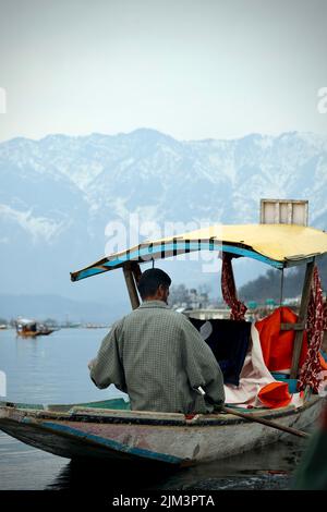 Ein Porträt eines kashmiri-Shikara-Bootssegler-Indianers auf dem Dal Lake. Die Hände können durch Bewegungen verschwommen sein. Stockfoto