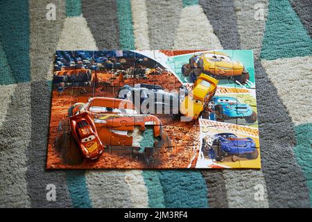 Die Mattel Cruz Ramirez und Lightning McQueen auf einem Trefl Disney Pixar Cars Puzzle. Stockfoto