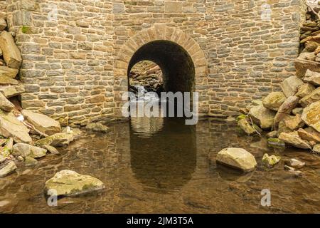 Eine wunderschöne Bogenbrücke mit See im Roland Park in Baltimore, Maryland, USA Stockfoto