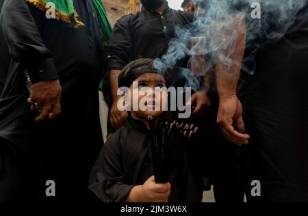 Srinagar, Indien. 04. August 2022. Ein muslimischer Junge der schiitischen Kashmiri hält während einer religiösen Prozession am 5.. Tag des Muharram Räucherstäbchen. Muharram ist der erste Monat des Islam. Es ist einer der heiligsten Monate im islamischen Kalender. Schiitische Muslime gedenken Muharram als einen Monat der Trauer zum Gedenken an das Martyrium des Enkels des islamischen Propheten Muhammad Imam Hussain, der 680 n. Chr. in der Schlacht von Karbala an Aschura (10.. Tag von Muharram) getötet wurde (Foto: Idrees Abbas/SOPA Images/Sipa USA) Quelle: SIPA USA/Alamy Live News Stockfoto