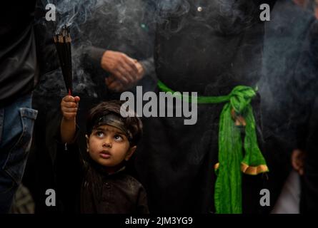 4. August 2022, Srinagar, Jammu und Kashmir, Indien: Ein muslimischer Junge aus der Kaschmir-Shia hält während einer religiösen Prozession am 5.. Tag des Muharram Räucherstäbchen in der Büsche. Muharram ist der erste Monat des Islam. Es ist einer der heiligsten Monate im islamischen Kalender. Schiitische Muslime gedenken Muharram als einen Monat der Trauer zum Gedenken an das Martyrium des Enkels des islamischen Propheten Muhammad Imam Hussain, der 680 n. Chr. in der Schlacht von Karbala an Aschura (10.. Tag Muharram) getötet wurde. (Foto: © Idrees Abbas/SOPA Images via ZUMA Press Wire) Stockfoto