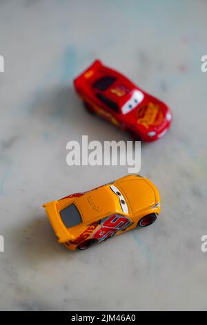 Eine vertikale Aufnahme von Mattel Cruz Ramirez und Lightning McQueen Spielzeugmodellautos aus dem Disney Cars Film Stockfoto