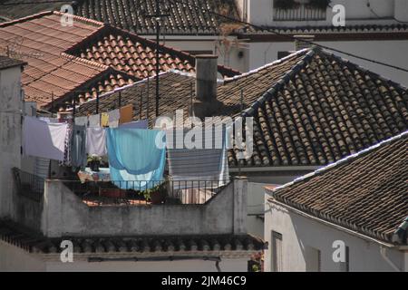Nahaufnahme von typischen Dächern Südspaniens mit hängenden Kleidern Stockfoto