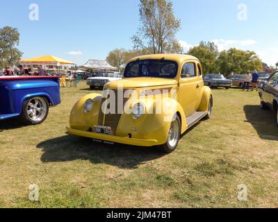 Vintage Ford Coupé 1937 auf dem Land. Natur Gras und Bäume Hintergrund. Oldtimer-Show. Copyspace Stockfoto