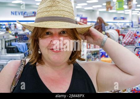 Miami Florida, Marshalls Kaufhaus im Inneren, Markt Shopping Shopper reife hispanische Erwachsene Frau versucht, auf Hut versuchen Stockfoto