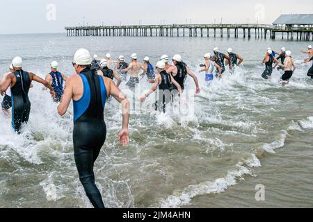 Hampton Virginia,Tidewater Area,Buckroe Beach,Tri American Triathlon jährliche Veranstaltung,Schwimmer Männer männliche Teilnehmer beginnen ein Wettlauf ins Wasser Stockfoto