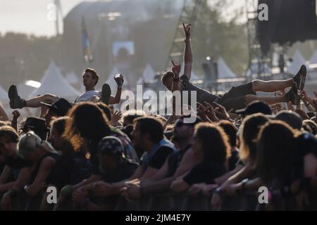 Wacken, Deutschland. 04. August 2022. Metal-Fans feiern beim Auftritt der Band 'Dirkschneider' beim Wacken Open Air (WOA). Es gilt als das größte Heavy Metal Festival der Welt. Quelle: Frank Molter/dpa/Alamy Live News Stockfoto