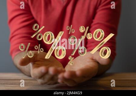 Die Hände einer Person mit illustrierenden Prozentsymbolen, die über den Händen schweben. Geschäftskonzept. Stockfoto