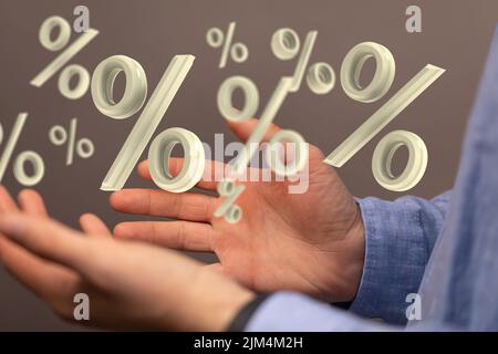 Die Hand einer Person mit illustrativen Prozentsymbolen, die über den Händen schweben. Geschäftskonzept. Stockfoto