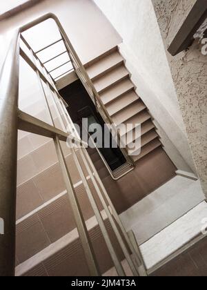 Eine Treppe mit Stufen und Handläufen von oben nach unten. Geometrie wird erzeugt Stockfoto