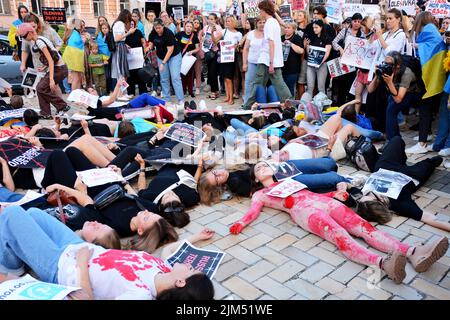 Kiew, Ukraine. 04. August 2022. Demonstranten liegen während eines Protestes zur Unterstützung der Soldaten des Asow-Bataillons, die am 29. Juli 2022 im Konzentrationslager in Oleniwka, im besetzten Gebiet der Ukraine, von russischen Militärs gefoltert wurden, auf dem Boden. Aktivisten und Verwandte versammelten sich auf dem Sofijivska-Platz, um die Aufmerksamkeit der internationalen Organisationen auf russische Kriegsverbrechen in der Ukraine nach dem Beginn einer umfassenden militärischen Invasion am 24. Februar 2022 zu lenken. (Foto: Aleksandr Gusev/SOPA Images/Sipa USA) Quelle: SIPA USA/Alamy Live News Stockfoto