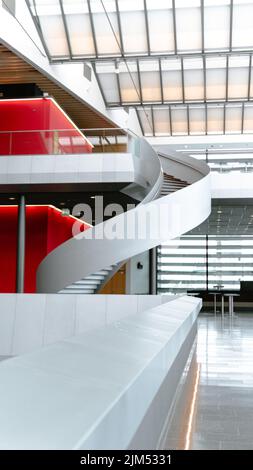 Eine vertikale Aufnahme des Innenraums eines neuen Gebäudes mit einer Wendeltreppe Stockfoto