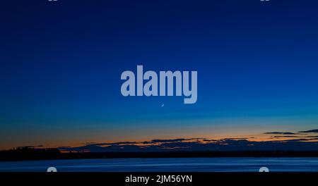 Juli 30 2022. Barnes Island. Blick nach dem Sonnenuntergang von Barnes Island. Zeigt Whaleboat Island und den zunehmenden Halbmond. Casco Bay, Maine Stockfoto