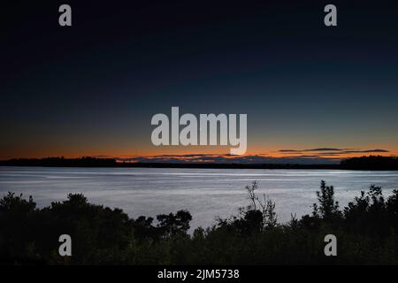 Juli 30 2022. Barnes Island. Blick nach dem Sonnenuntergang von Barnes Island. Zeigt Whaleboat Island und den zunehmenden Halbmond. Casco Bay, Maine Stockfoto