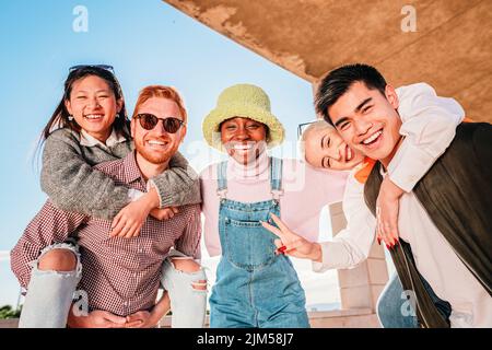 Eine Gruppe von fünf glücklichen jungen Freunden, die Spaß miteinander haben und lächeln. Stockfoto
