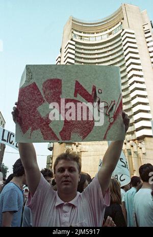 Bukarest, Rumänien, Juni 1990. „Golaniada“, ein großer Anti-Kommunismus-Protest auf dem Universitätsplatz nach der rumänischen Revolution von 1989. Die Menschen versammelten sich täglich, um gegen die Ex-Kommunisten zu protestieren, die nach der Revolution die Macht übernahmen. Auf diesem Bild hält ein Mann ein Zeichen, das die neue Partei an der Macht (F.S.N.) mit den Sowjets verbindet. Stockfoto