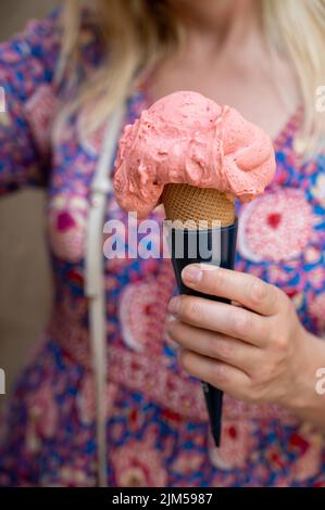 Frau hält Obst veganes Eis in Waffelkegel auf der Straße, Nahaufnahme Stockfoto