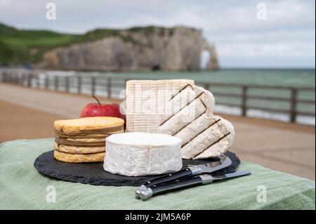 Vier berühmte Käse der Normandie, quadratische pont l'eveque, rund Camembert Kuhkäse, gelbe livarot, herzförmigen neufchatel und Blick auf die Promenade und ein Stockfoto