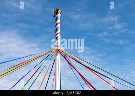 Eine Stange mit farbigen Bändern und Blumen an einem traditionellen englischen Maypole-Tanztag Stockfoto