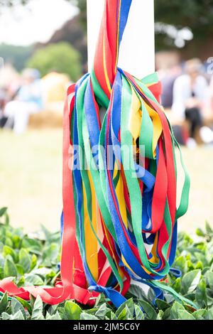 Die farbigen Bänder, die an einem traditionellen englischen Maypole-Tanztag von der Stange hängen Stockfoto