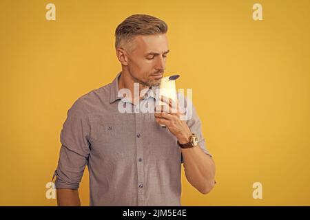 haarpflege und Hautpflege. Präsentation kosmetisches Produkt für Männer. Mann verwenden Duschgel. Stockfoto