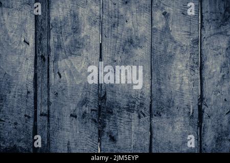 Eine Nahaufnahme von Graustufen von Holzplatten eines alten Holzzauns mit rostigen Nägeln bei Tageslicht Stockfoto