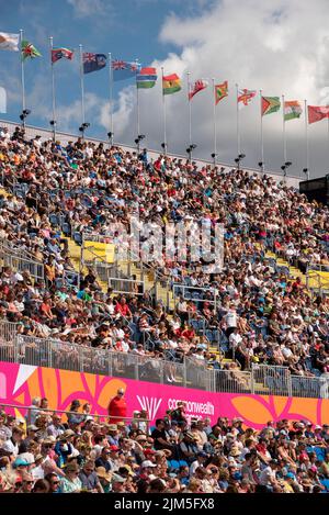 Birmingham, Großbritannien, 4.. August 2022. Zuschauer im Alexander Stadium, Birmingham, genießen die Leichtathletik bei den Commonwealth Games 2022. Flaggen der Commonwealth-Staaten fliegen über das Stadion. Quelle: Martin Anderson/Alamy Live News Stockfoto