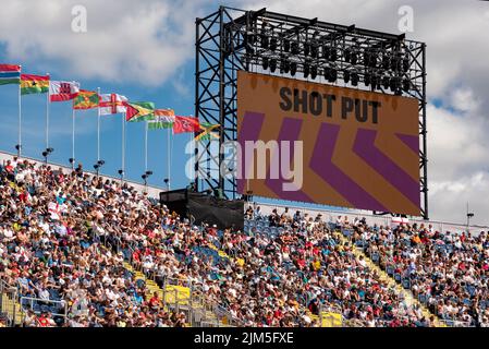 Birmingham, Großbritannien, 4.. August 2022. Zuschauer im Alexander Stadium, Birmingham, genießen die Leichtathletik bei den Commonwealth Games 2022. Flaggen der Commonwealth-Staaten fliegen über das Stadion. Quelle: Martin Anderson/Alamy Live News Stockfoto