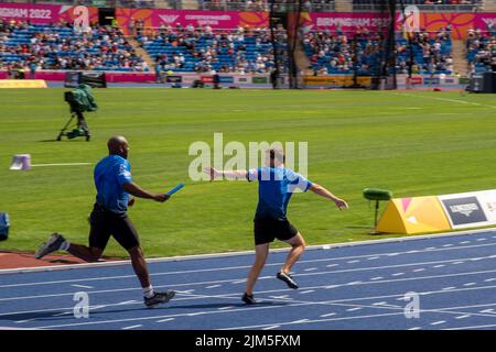 Birmingham, Großbritannien, 4.. August 2022. Mark Rhodes (TV-Moderator für Kinder) empfängt den Staffelstab von Darren Harriott (Komiker) während der 4 x 100m-Staffel im Teil Sport Relief All-Stars der Veranstaltung bei den Commonwealth Games 2022. Das Team gewann das Rennen. Die Veranstaltung Sport Relief All-Stars wird von der BBC im Rahmen der Commonwealth Games und Sport Relief gezeigt. Quelle: Martin Anderson/Alamy Live News Stockfoto