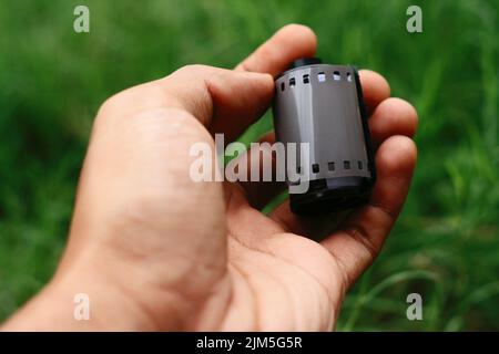 Nahaufnahme von Hand haltenden Filmnegativen oder Filmkanistern Stockfoto