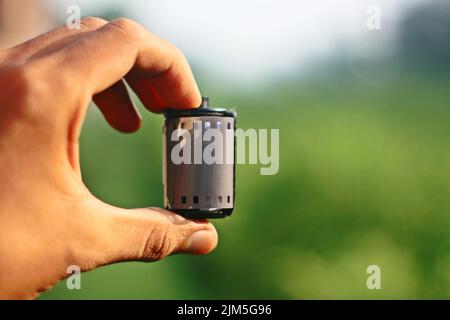 Nahaufnahme von Hand haltenden Filmnegativen und Rollenfilm Stockfoto