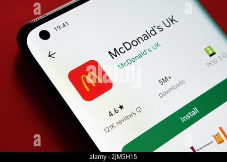 Die McDonald's UK App wird im Google Play Store auf dem Smartphone-Bildschirm auf rotem Hintergrund angezeigt. Nahaufnahme mit selektivem Fokus. Stafford, Vereinigte Staaten von Amerika Stockfoto