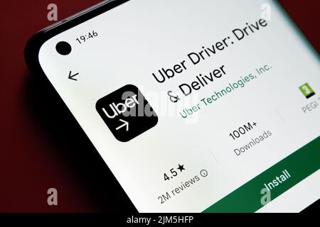 Uber Driver App in Google Play Store auf dem Smartphone-Bildschirm auf rotem Hintergrund platziert gesehen. Nahaufnahme mit selektivem Fokus. Stafford, United Kin Stockfoto