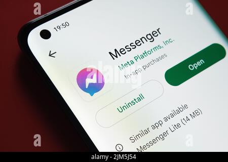 Facebook Messenger-App im Google Play Store auf dem Smartphone-Bildschirm auf rotem Hintergrund angezeigt. Nahaufnahme mit selektivem Fokus. Stafford, Uni Stockfoto