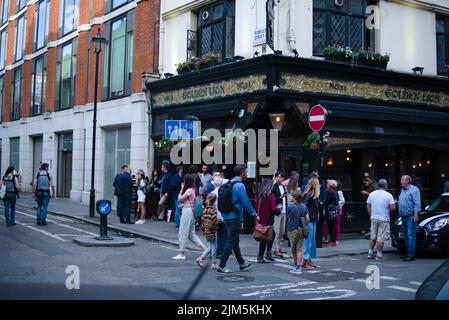 Eine Menge Leute versammelten sich vor einem authentischen Golden Lion Pub in Soho, London Stockfoto