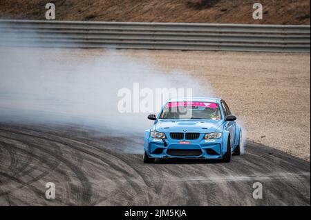 BMW 3 Series E90 driftet auf der Rennstrecke Stockfoto