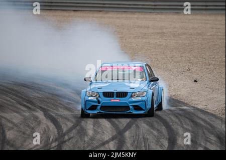 BMW 3 Series E90 driftet auf der Rennstrecke Stockfoto