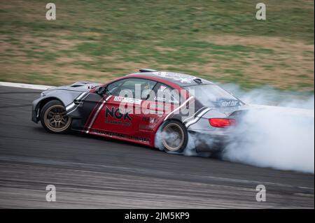 Schneller bicolor BMW M3 E92 driftet auf der Rennstrecke Stockfoto