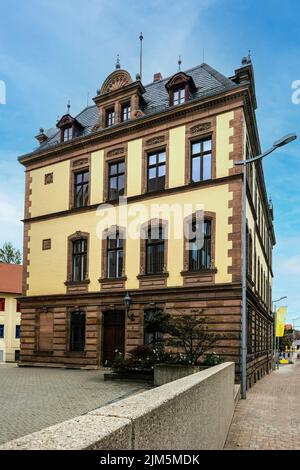 Eine vertikale Aufnahme der beigefarbenen und braunen Gebäudefassade unter blauem hellem Himmel Stockfoto