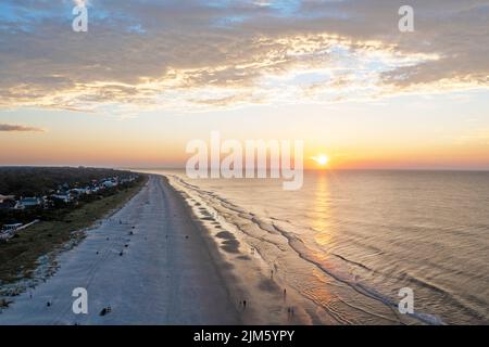 Blick aus der Vogelperspektive auf den Coligny Beach auf Hilton Head Island. Blick auf das Meer bei Sonnenuntergang mit Bäumen und Hotels im Vordergrund Stockfoto