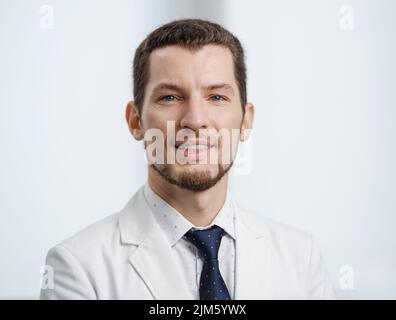Nahaufnahme Porträt eines lächelnden männlichen Zahnarztes in weißem Laborkittel, der die Kamera anschaut Stockfoto