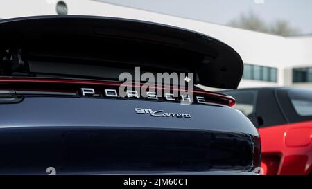 Blaues Porsche 911 Cabriolet-Heck, das draußen neben einer roten Acura NS geparkt ist Stockfoto