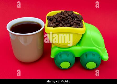 LKW, der Kaffeebohnen und eine Tasse Kaffee transportiert. Kaffeekonzept Stockfoto