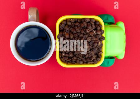 LKW, der Kaffeebohnen und eine Tasse Kaffee transportiert. Kaffeekonzept Stockfoto