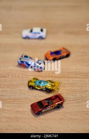 Eine vertikale Nahaufnahme von Mattel Hot Wheels Spielzeugmodellen auf einer Holzoberfläche. Stockfoto