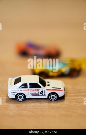 Eine vertikale Nahaufnahme von Mattel Hot Wheels Spielzeugmodellen auf einer Holzoberfläche. Stockfoto